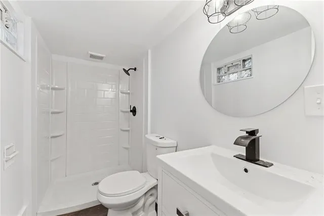 a bathroom with a toilet a sink and mirror