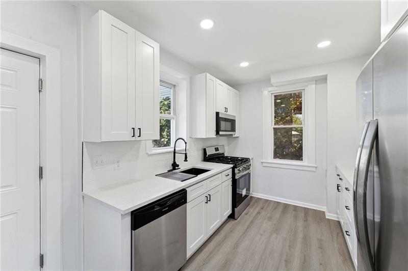 233 East 19th Avenue Homestead, PA 15120 - Photo 8 of 27 a kitchen with stainless steel appliances granite countertop a sink stove and refrigerator