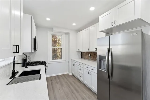 a kitchen with granite countertop a refrigerator and a sink