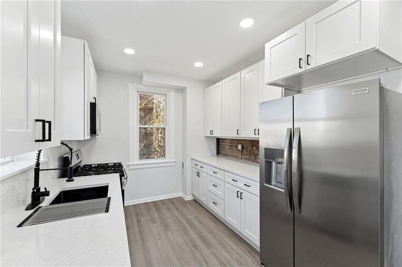 233 East 19th Avenue Homestead, PA 15120 - Photo 9 of 27 a kitchen with granite countertop a refrigerator and a sink
