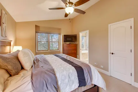a bedroom with a large bed and a chandelier