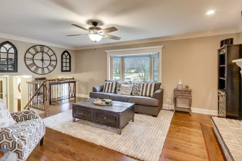 a living room with furniture a clock on wall and a table
