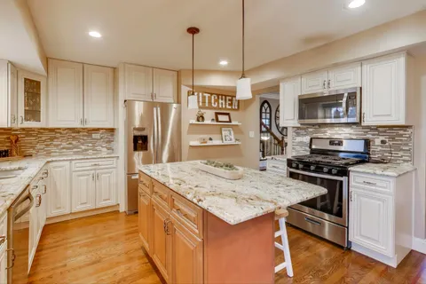 a kitchen with stainless steel appliances granite countertop a stove refrigerator sink and microwave