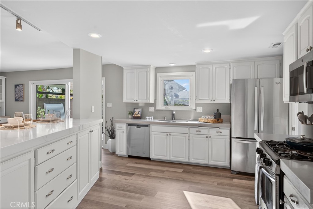 1610 East 20th Street Santa Ana, CA 92705 - Photo 12 of 43 a kitchen with white cabinets and appliances