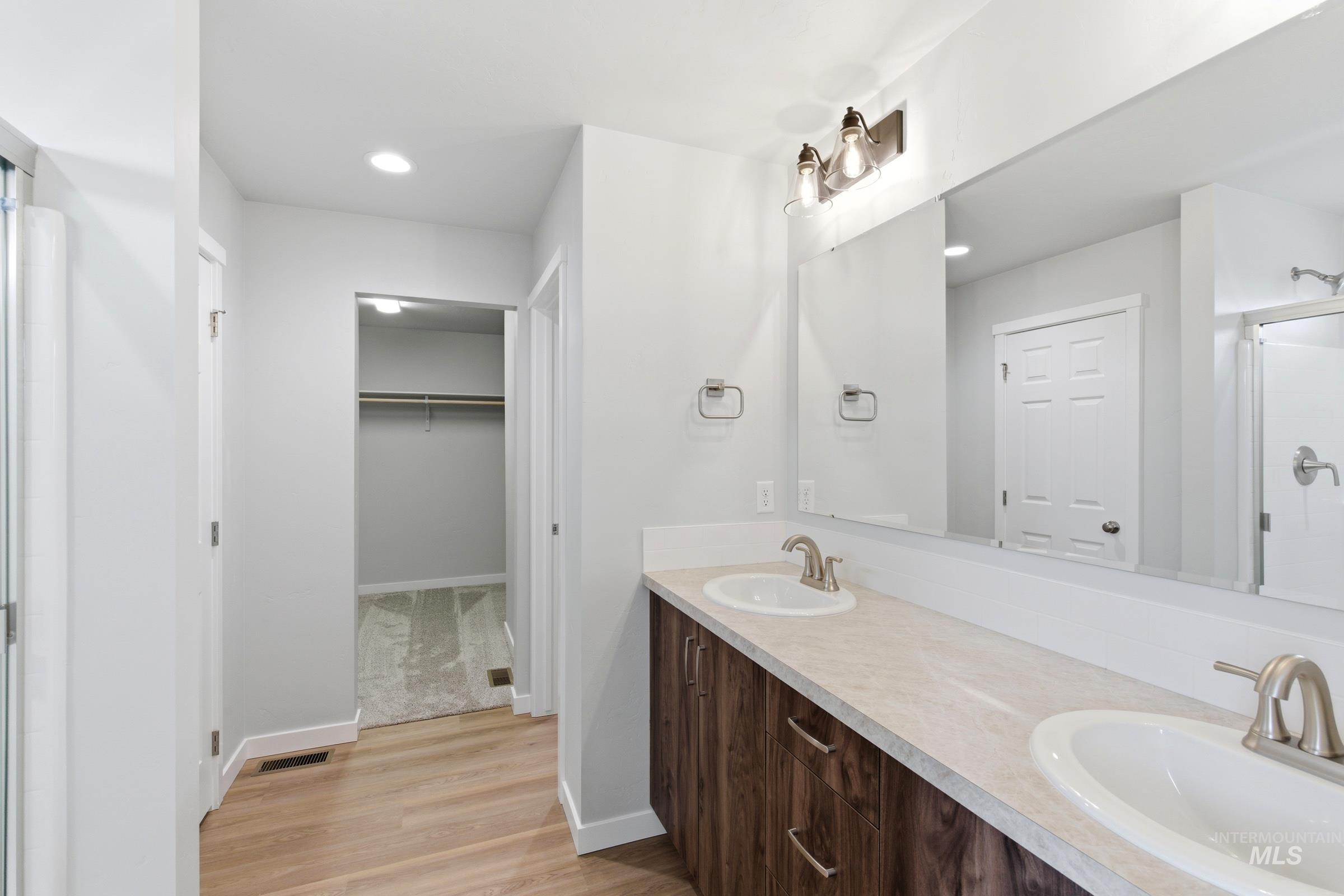 16558 Dunning Way Caldwell, ID 83607 - Photo 31 of 35 Double vanity featuring two undermount sinks, brushed nickel fixtures, and wood-finish cabinetry