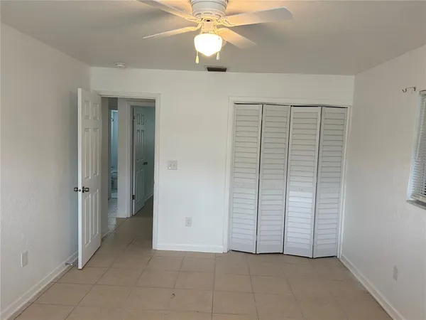 an empty room with fan and entrance