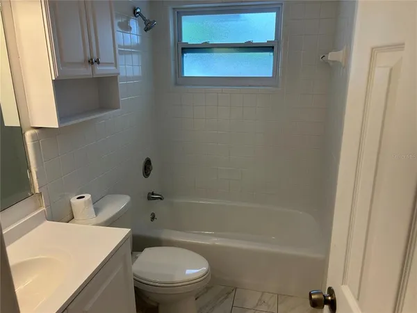 a bath room with a toilet a sink and a bath tub