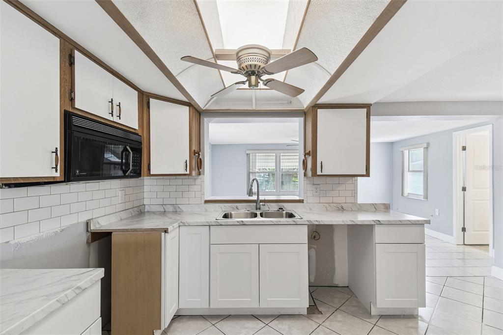 5410 Quist Drive Port Richey, FL 34668 - Photo 24 of 99 a kitchen with cabinets a window and stainless steel appliances