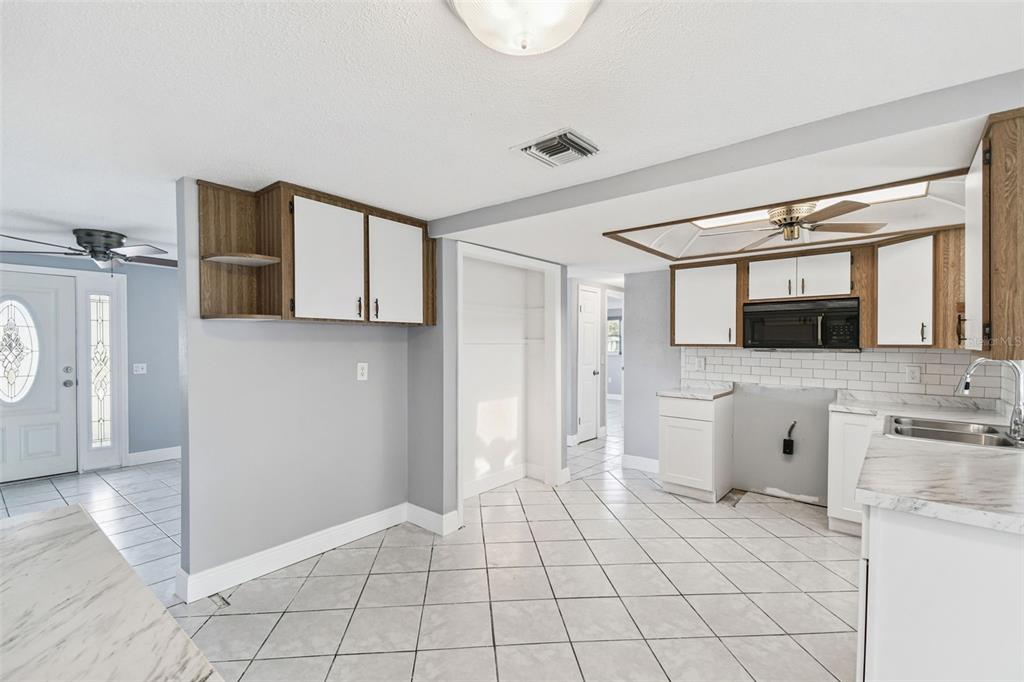5410 Quist Drive Port Richey, FL 34668 - Photo 27 of 99 a view of a kitchen with a sink and dishwasher a refrigerator with white cabinets