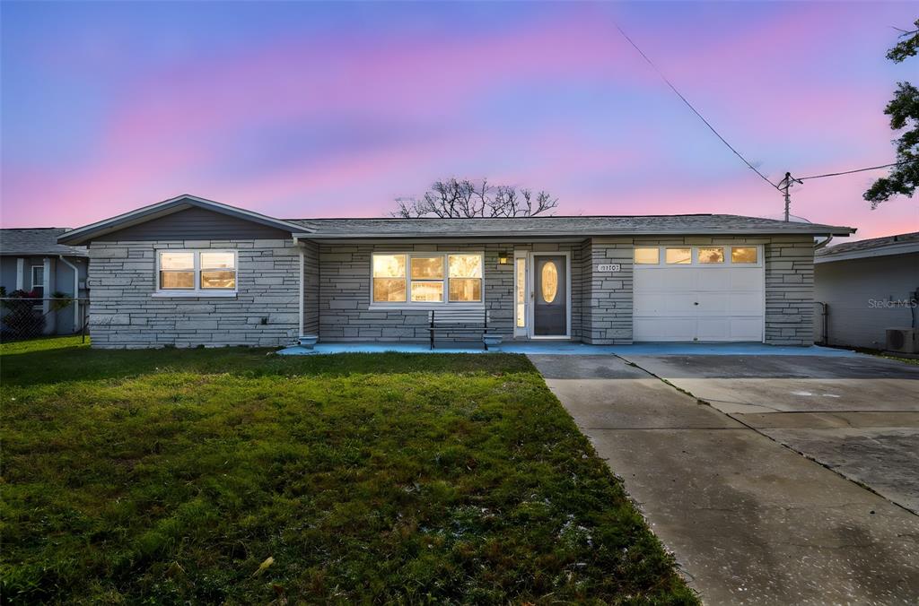 5410 Quist Drive Port Richey, FL 34668 - Photo 6 of 99 a front view of a house with a garden and yard