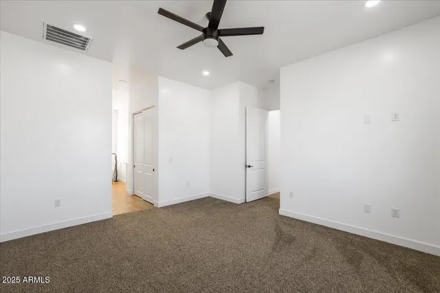 en empty room with ceiling fan and window
