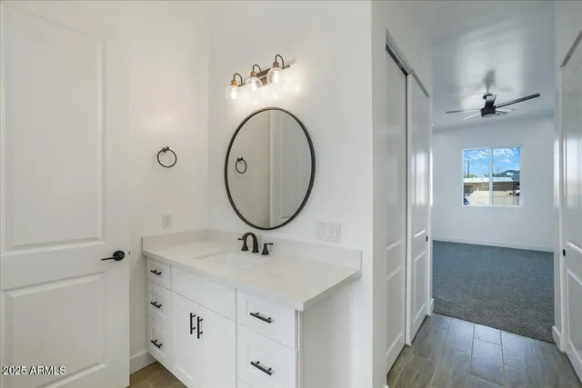 a bathroom with a granite countertop sink a mirror and a wooden floor