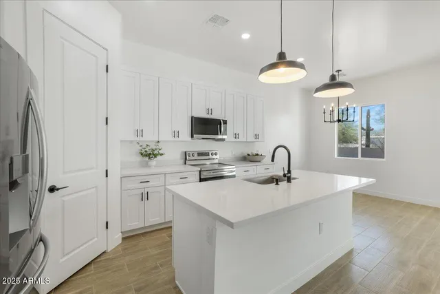 a kitchen with stainless steel appliances a sink a stove a microwave and cabinets