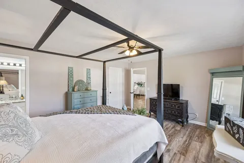 a bedroom with a bed a flat screen tv and dresser