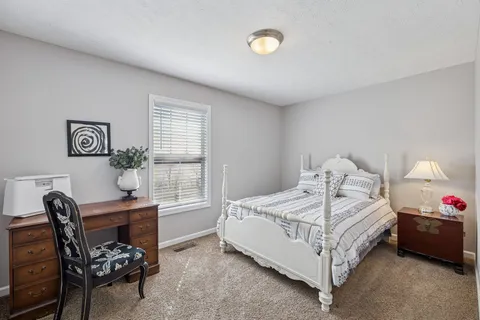 a bedroom with a bed chair and a window