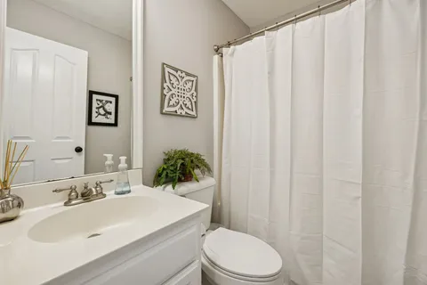 a bathroom with a sink a toilet and shower curtain