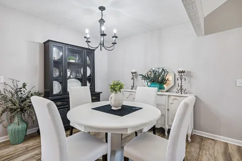 a view of a dining room with furniture wooden floor and chandelier