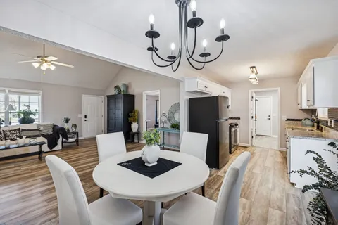 a view of a dining room with furniture a chandelier and wooden floor