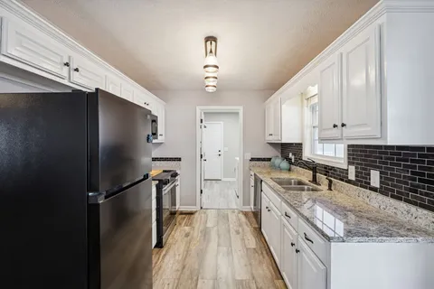a kitchen with a refrigerator a sink and cabinets