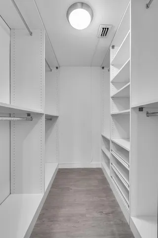 a view of walk in closet with empty racks