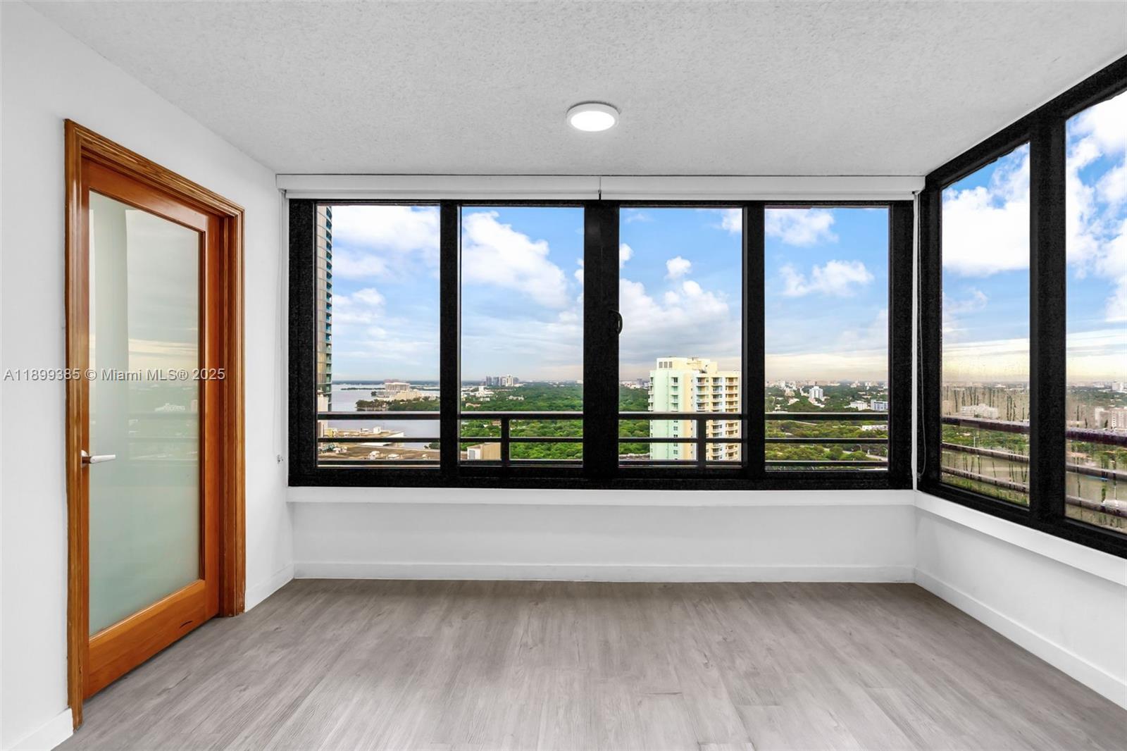 2333 Brickell Avenue, Unit PH208 Miami, FL 33129 - Photo 2 of 40 a view of an empty room with wooden floor and a window