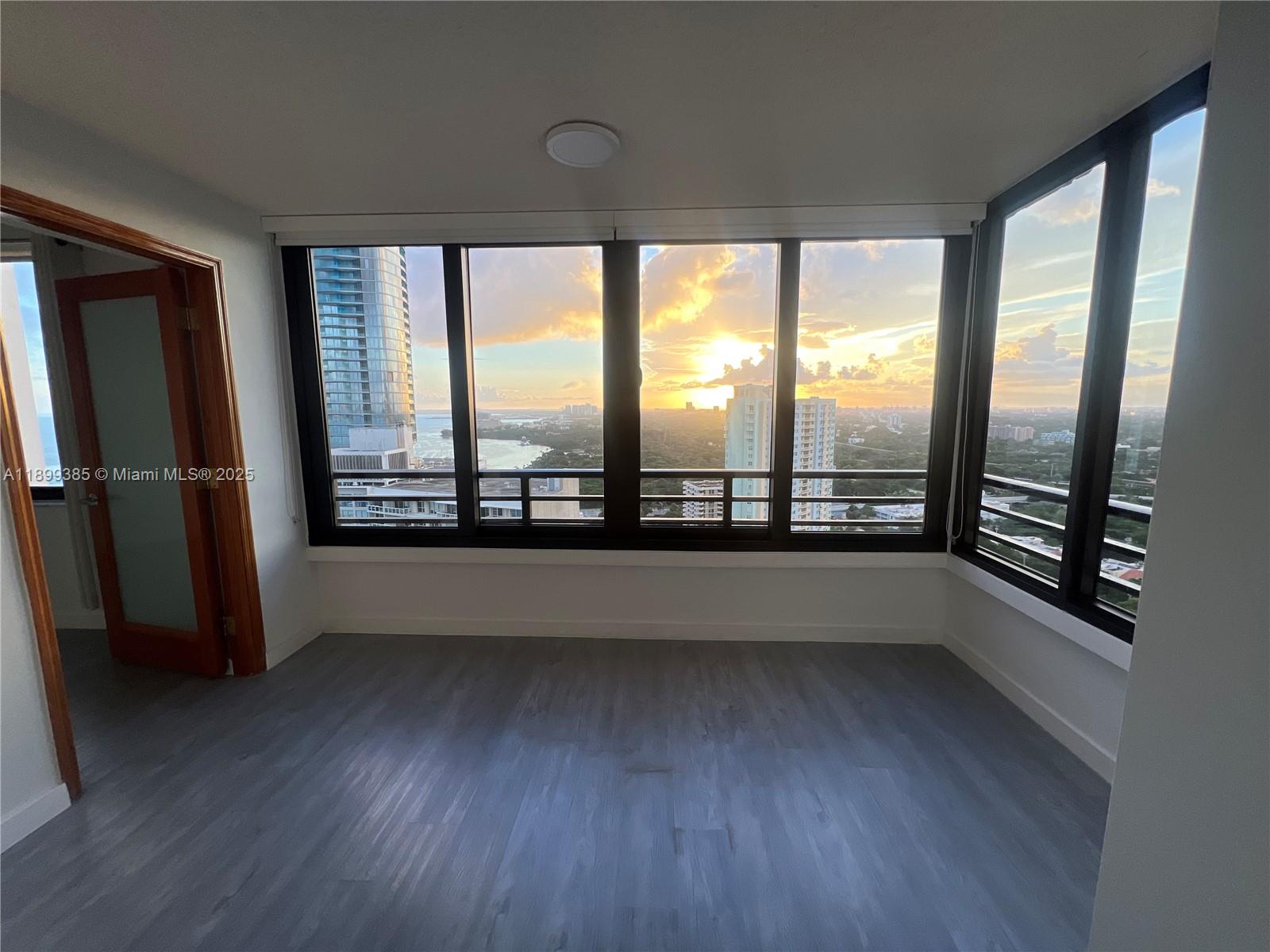 2333 Brickell Avenue, Unit PH208 Miami, FL 33129 - Photo 3 of 40 a view of an empty room with wooden floor and a window