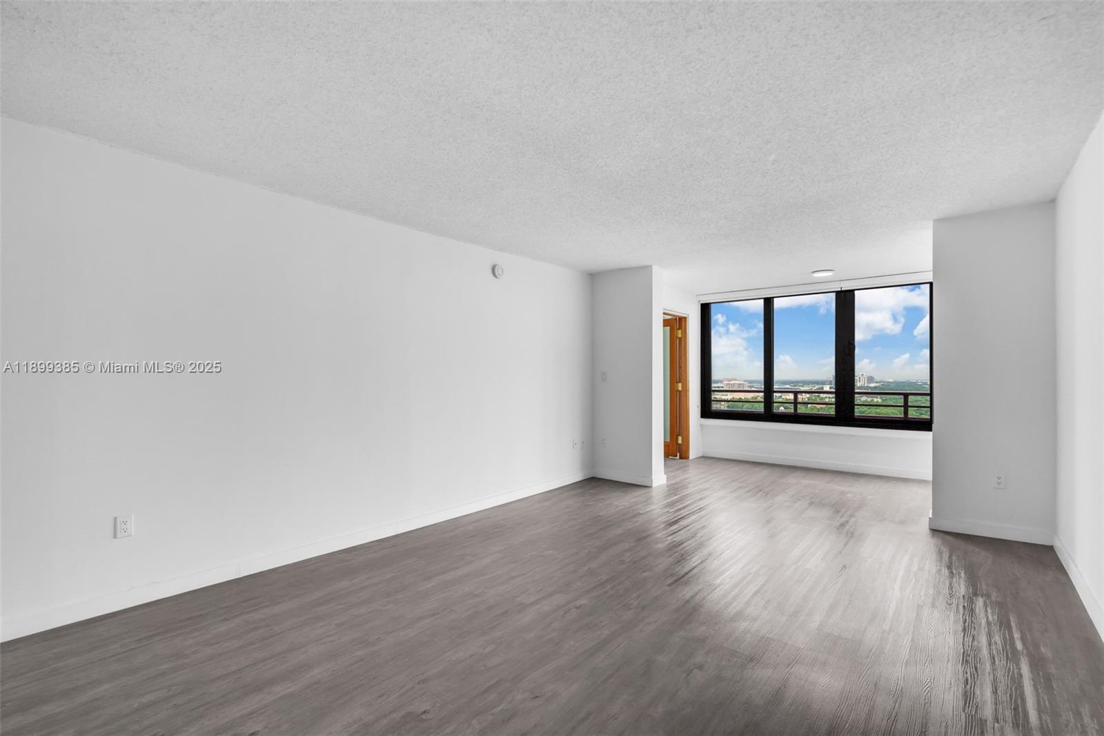 2333 Brickell Avenue, Unit PH208 Miami, FL 33129 - Photo 6 of 40 a view of an empty room with wooden floor and a window