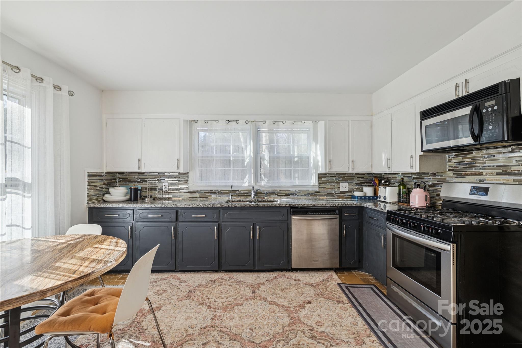236 Little River Road Fort Mill, SC 29707 - Photo 16 of 22 a kitchen with stainless steel appliances granite countertop a stove top oven a sink dishwasher a dining table and chairs