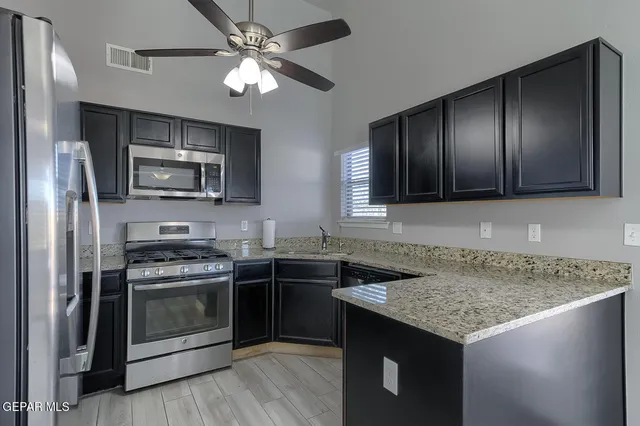 a kitchen with stainless steel appliances granite countertop a stove sink microwave and refrigerator