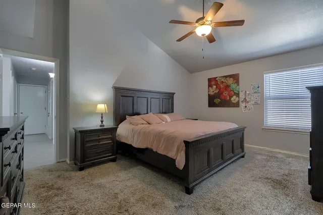 a spacious bedroom with a bed and a chandelier
