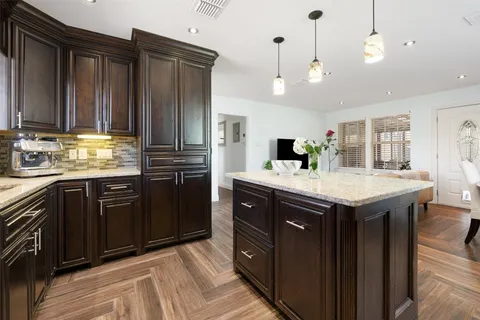 a kitchen with granite countertop stainless steel appliances and wooden cabinets