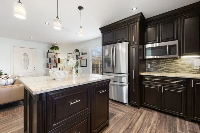 a kitchen with stainless steel appliances granite countertop a sink stove and refrigerator