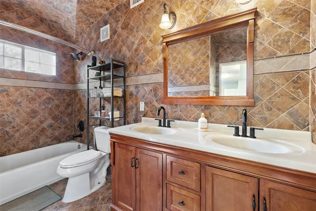 a bathroom with a granite countertop sink toilet a mirror and shower
