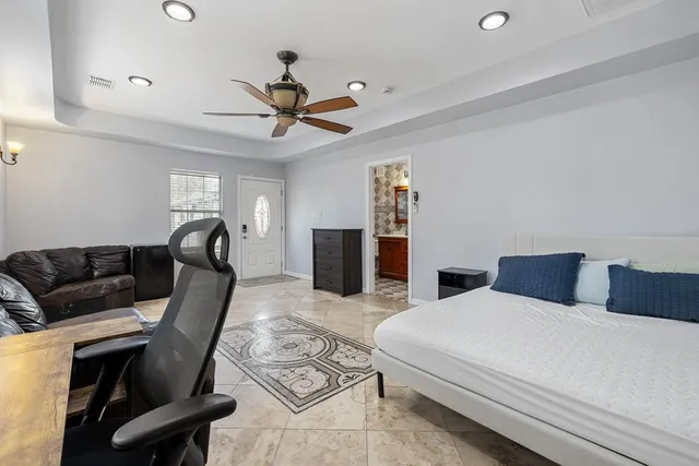 a bedroom with furniture and a ceiling fan