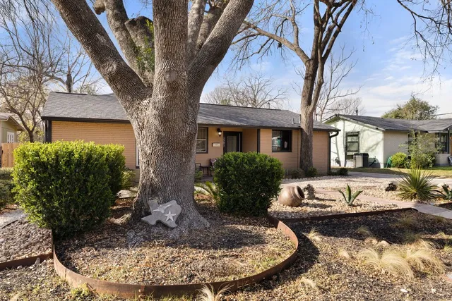 a front view of house with yard and trees around