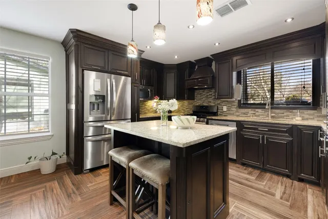 a kitchen with kitchen island a sink dining table and chairs