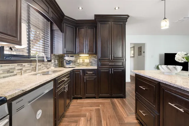 a kitchen with granite countertop a sink stove and refrigerator