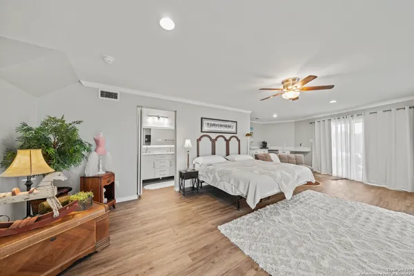 a spacious bedroom with a large bed and a chandelier