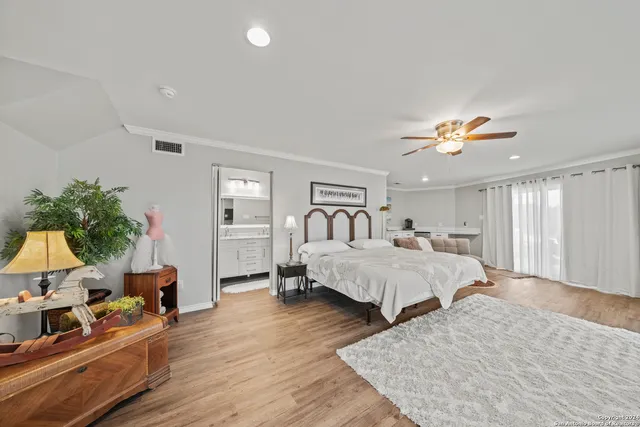 a spacious bedroom with a large bed and a chandelier