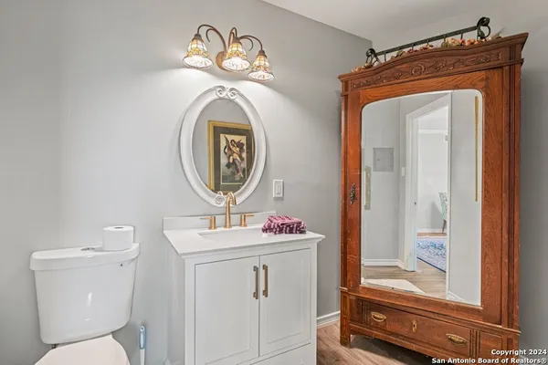 a bathroom with a toilet sink vanity and mirror