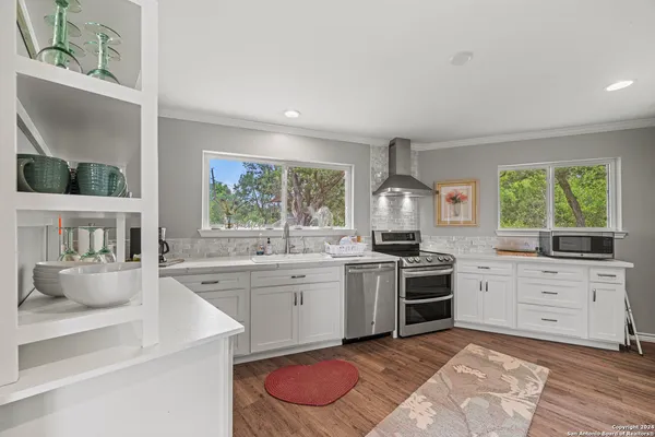 a kitchen with a stove a sink and a window