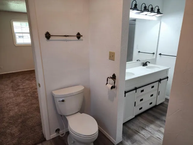 a bathroom with a sink a toilet a mirror and shower