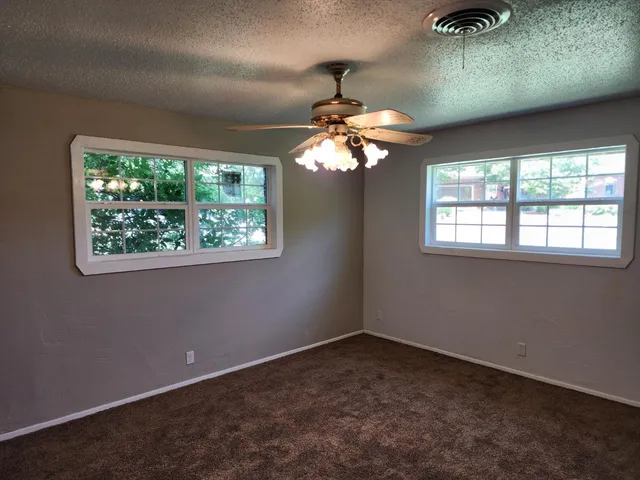 en empty room with windows and chandelier