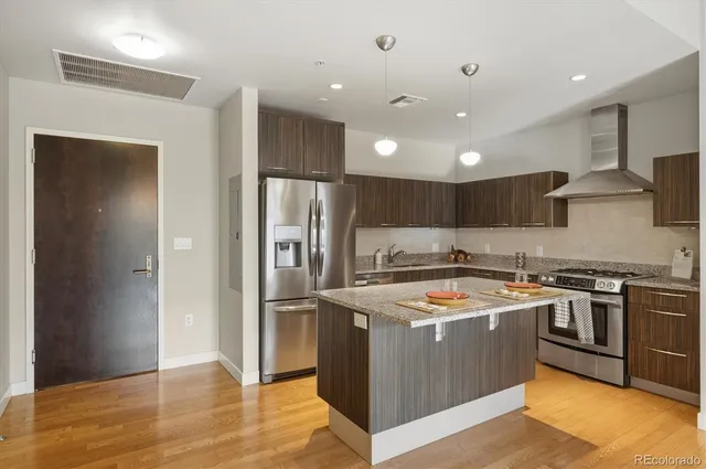 a kitchen with stainless steel appliances granite countertop a stove a refrigerator and a sink