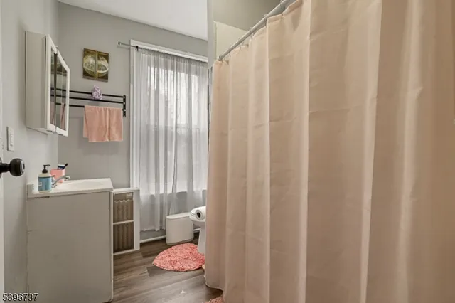 a bathroom with a sink toilet and shower curtain