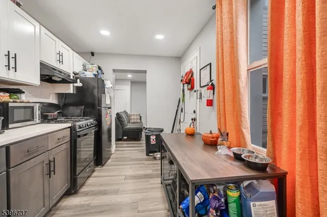 a kitchen that has a lot of cabinets a sink and a wooden floor