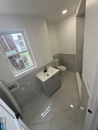 a bathroom with a toilet sink and mirror