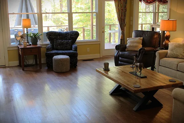 a living room with furniture a table and large windows