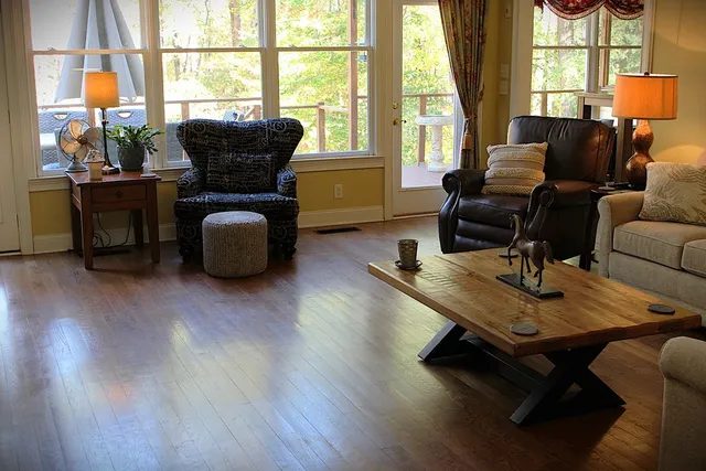 a living room with furniture a table and large windows