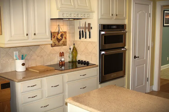 a kitchen with granite countertop white cabinets and stainless steel appliances